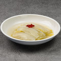 White bowl with a dish of cabbage on a gray background