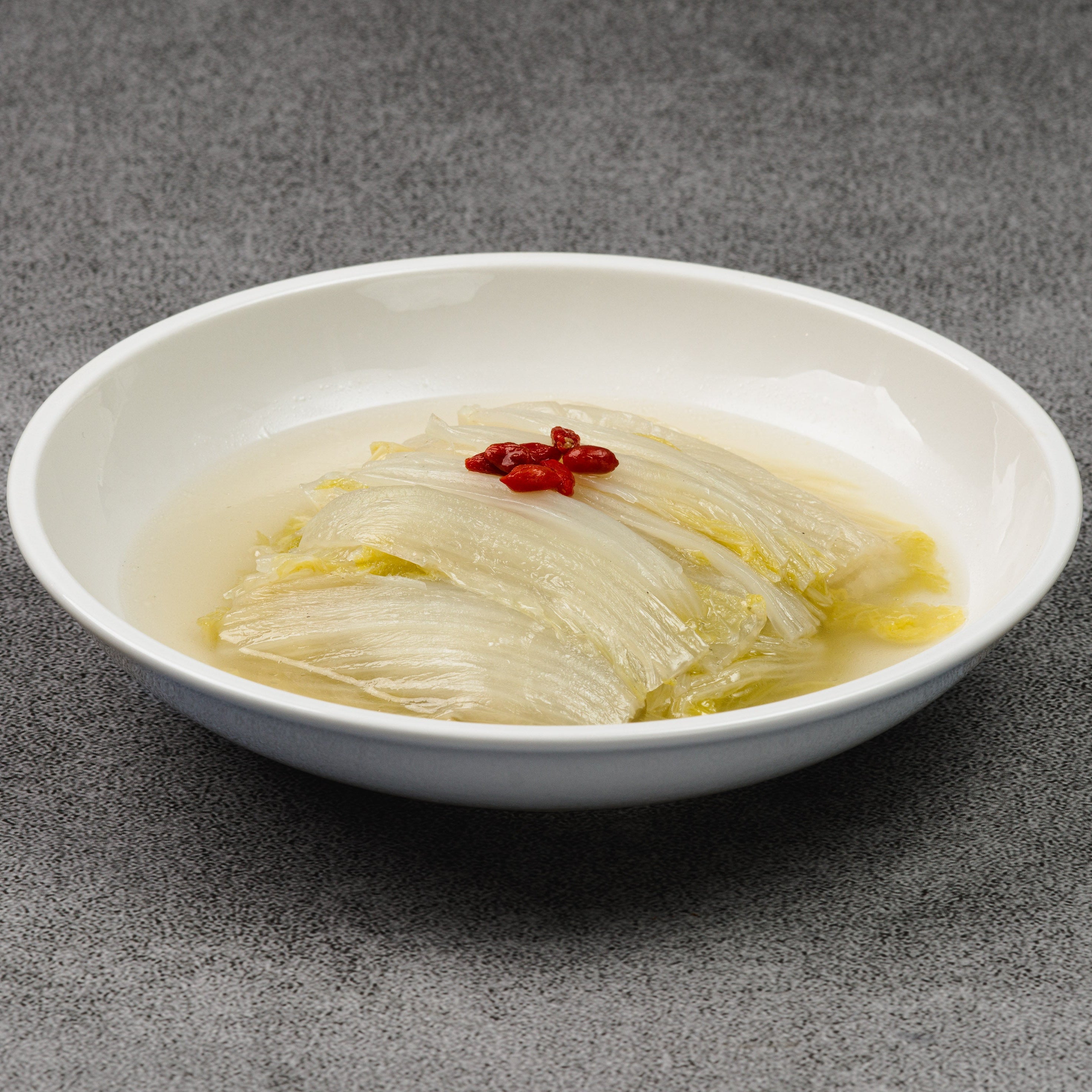 White bowl with a dish of cabbage on a gray background