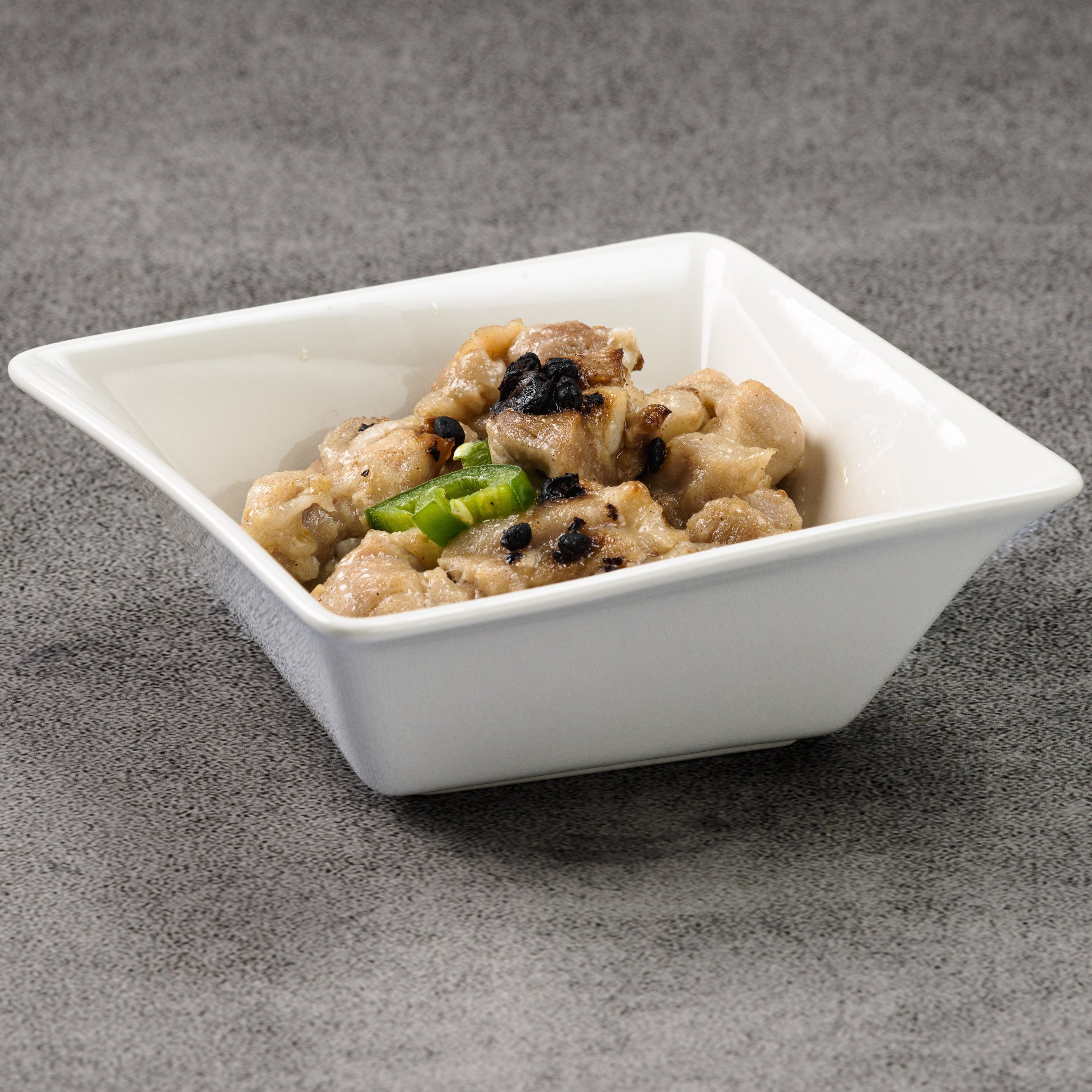 White square bowl with food on a gray surface
