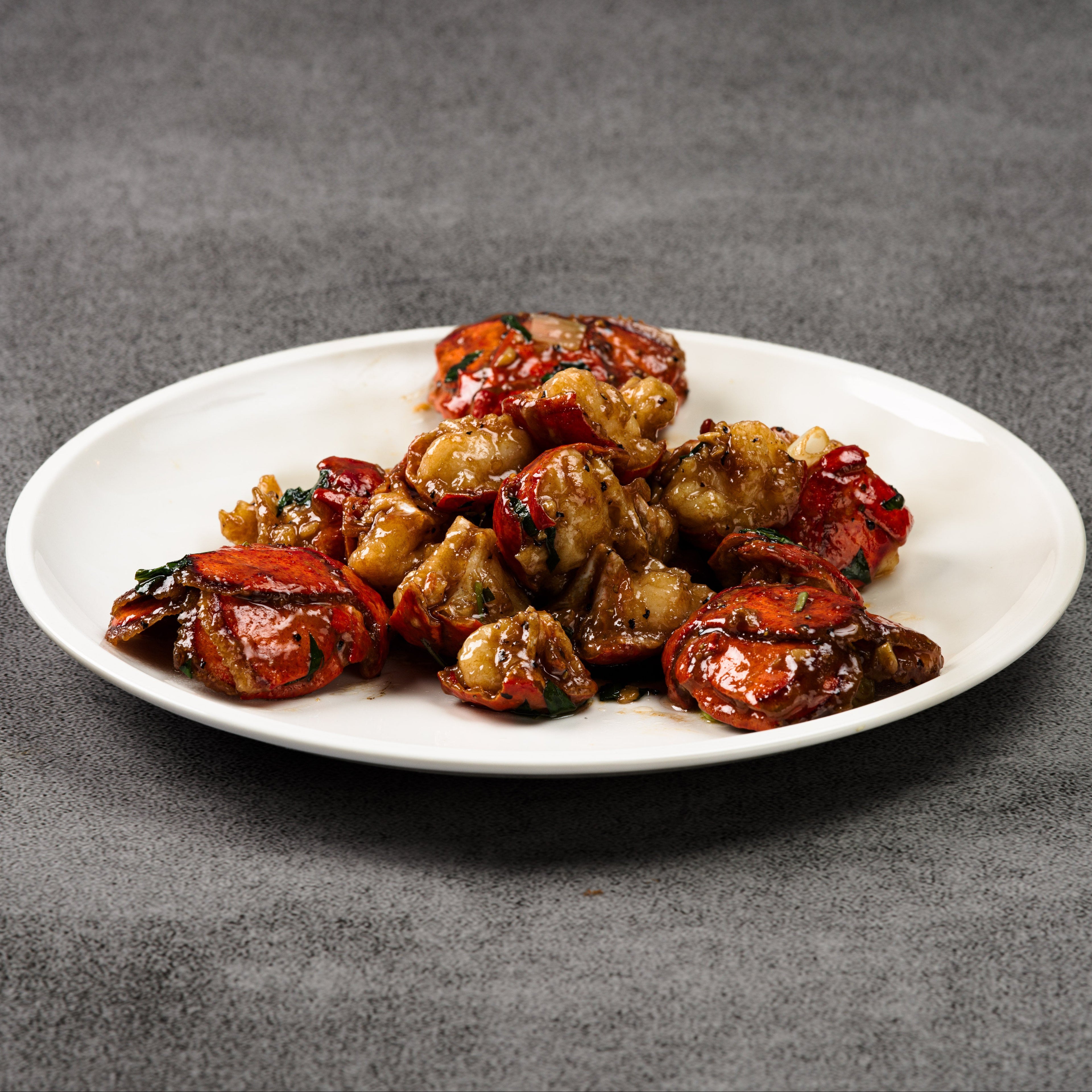White plate with cooked lobster on a gray background