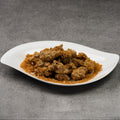 White plate with fried pork pieces on a gray background