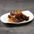 Crispy garlic ribs on a white plate with a gray background