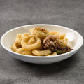 White bowl with fried calamari on a gray background