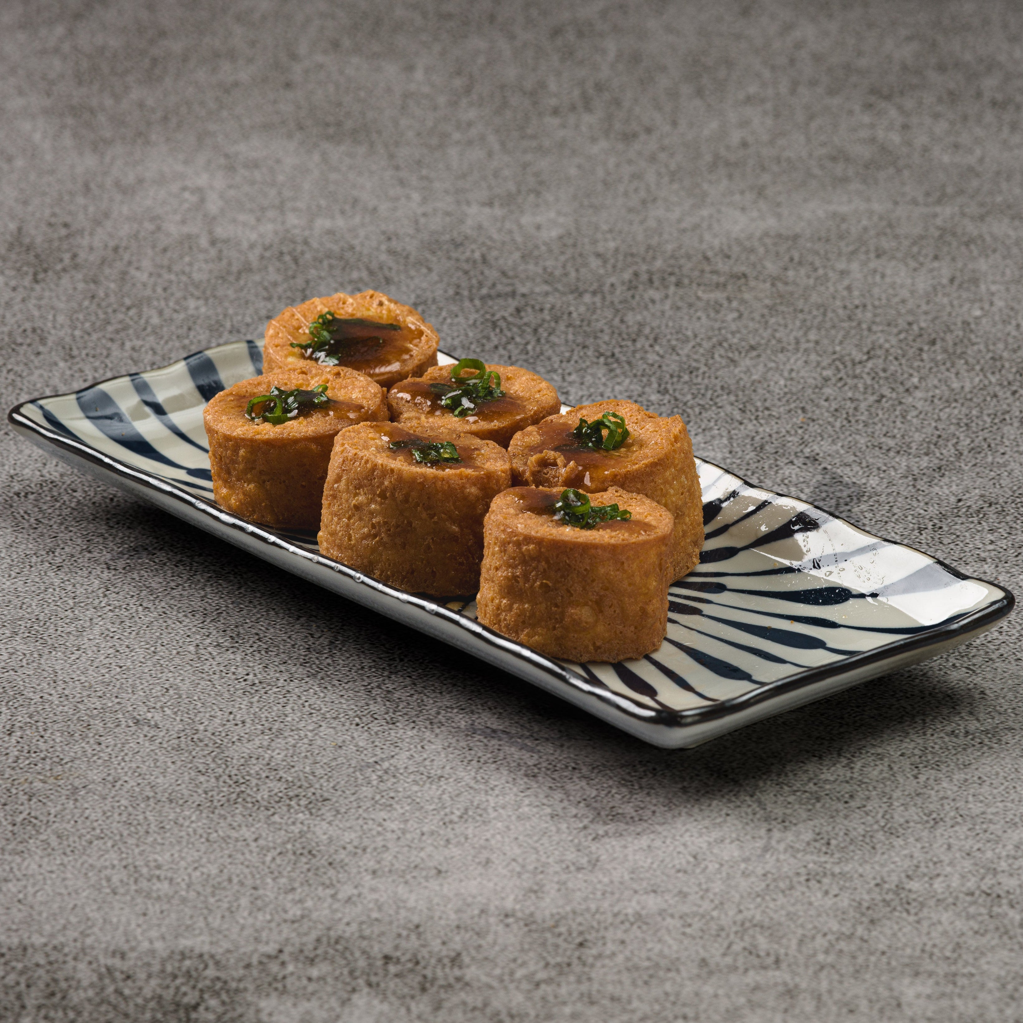 Crispy fried egg tofu on a decorative plate with a gray background