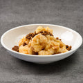 White bowl with honey walnut shrimp on a gray background