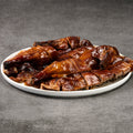 Roasted duck on a white plate with a gray background