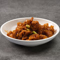 White bowl with orange chicken on a gray background