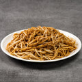 Plate of noodles with garlic on a gray background