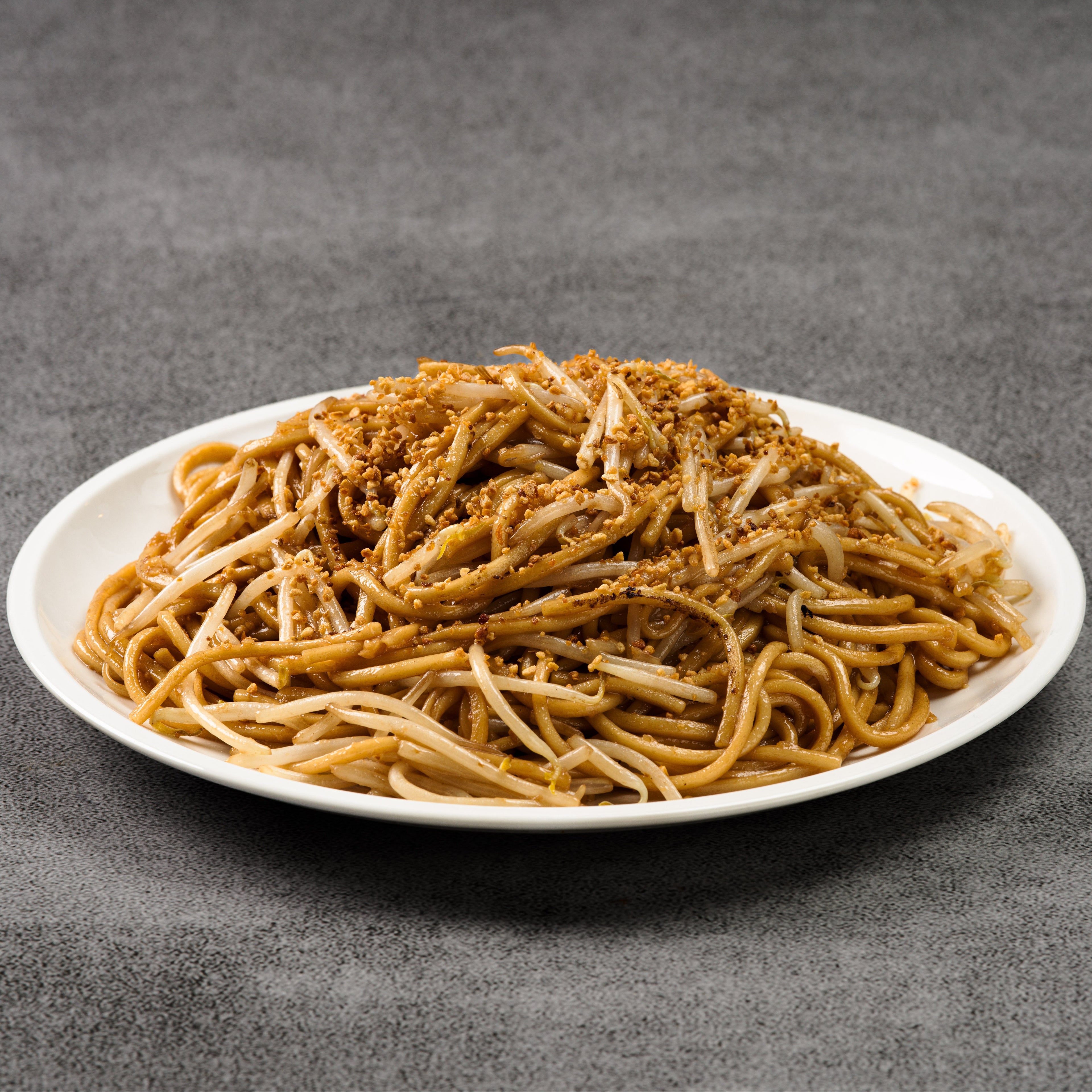 Plate of noodles with garlic on a gray background