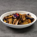 White bowl filled with cooked eggplant on a gray background