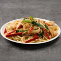 Seafood and noodles on a white plate on a gray background