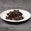 Plated dish of beef on a gray background